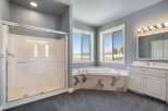 Indulge in relaxation in this spacious master bathroom, featuring a luxurious corner soaking tub with a stunning marble surround.