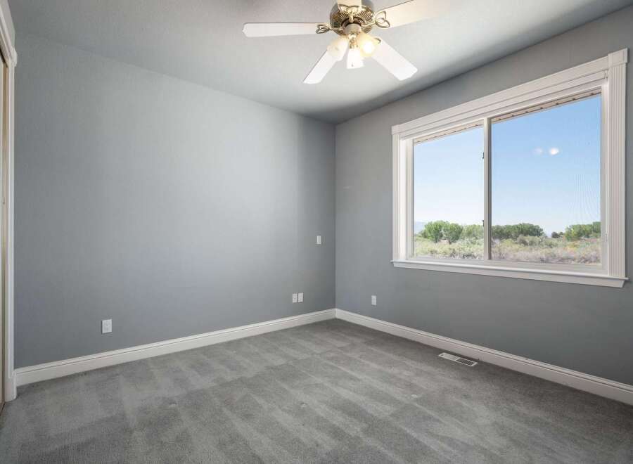 This spacious bedroom features a neutral gray color palette, creating a serene and calming atmosphere.