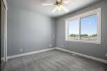 This spacious bedroom features a neutral gray color palette, creating a serene and calming atmosphere.