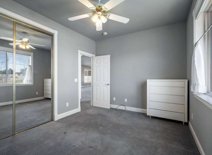 This spacious bedroom features a large mirrored closet, perfect for maximizing storage and creating an illusion of more space.