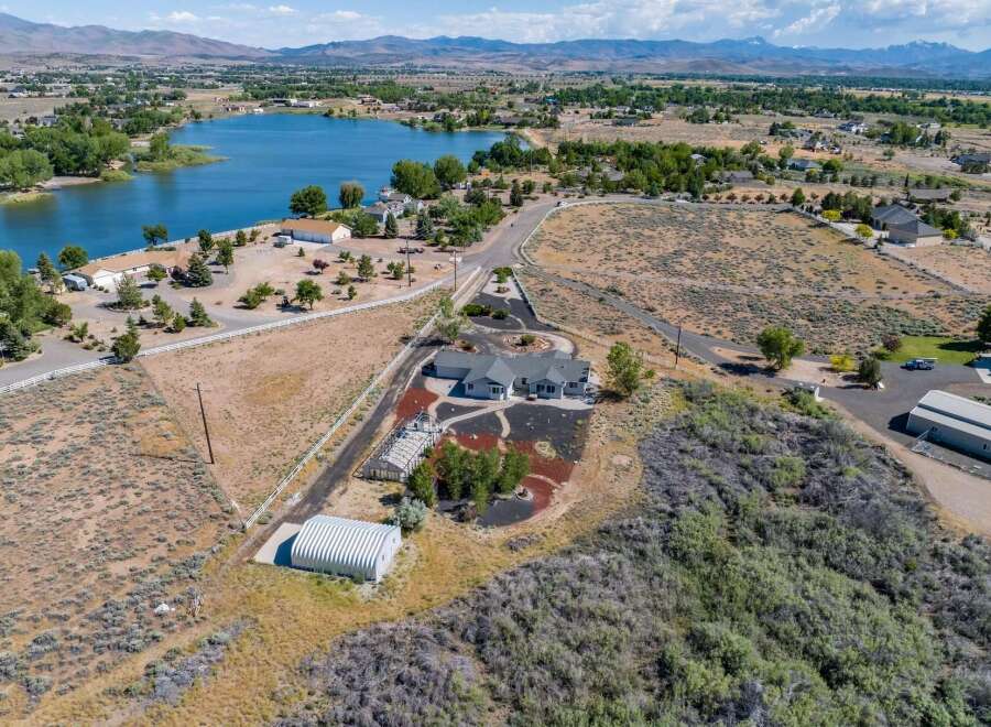Discover this stunning property featuring a spacious home with a modern design, complemented by a large greenhouse and a convenient Quonset hut for storage.