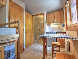 Discover this charming studio apartment featuring a cozy sleeping area with a bunk bed and a compact kitchenette equipped for your culinary needs.