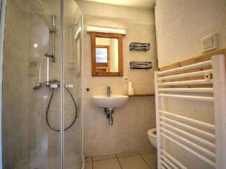 This bathroom features a modern shower enclosure with a chrome showerhead and controls.
