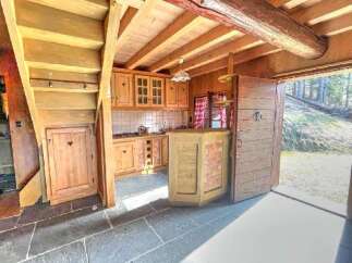 Discover this charming rustic kitchen featuring warm wooden cabinetry and a cozy breakfast bar with brick accents.