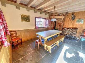Experience rustic charm in this cozy dining area, featuring a sturdy wooden table and bench set perfect for family meals.