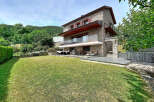 Discover this stunning stone house nestled in a serene, green landscape.