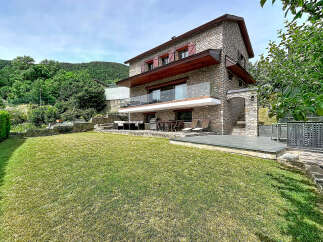 Discover this stunning stone house nestled in a serene, green landscape.