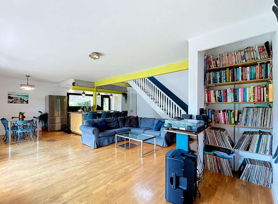 Discover this spacious open-plan living area, perfect for entertaining, featuring a large sectional sofa and a modern dining set.
