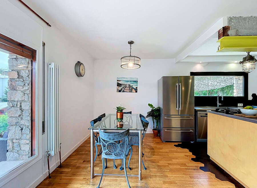This modern dining area features a sleek glass-top dining table with industrial-style chairs, perfect for intimate meals.