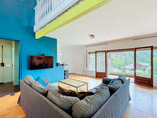 Experience breathtaking mountain views from this stunning living room, featuring a large sectional sofa and a modern entertainment center.