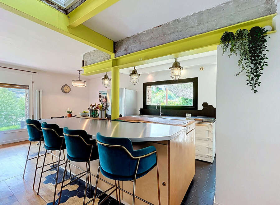 Experience modern industrial living in this stunning kitchen featuring vibrant lime green beams and exposed concrete accents.