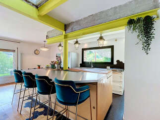 Experience modern industrial living in this stunning kitchen featuring vibrant lime green beams and exposed concrete accents.