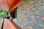 Experience the charm of this rustic property featuring a beautiful stone facade and a warm wooden ceiling on the covered patio.