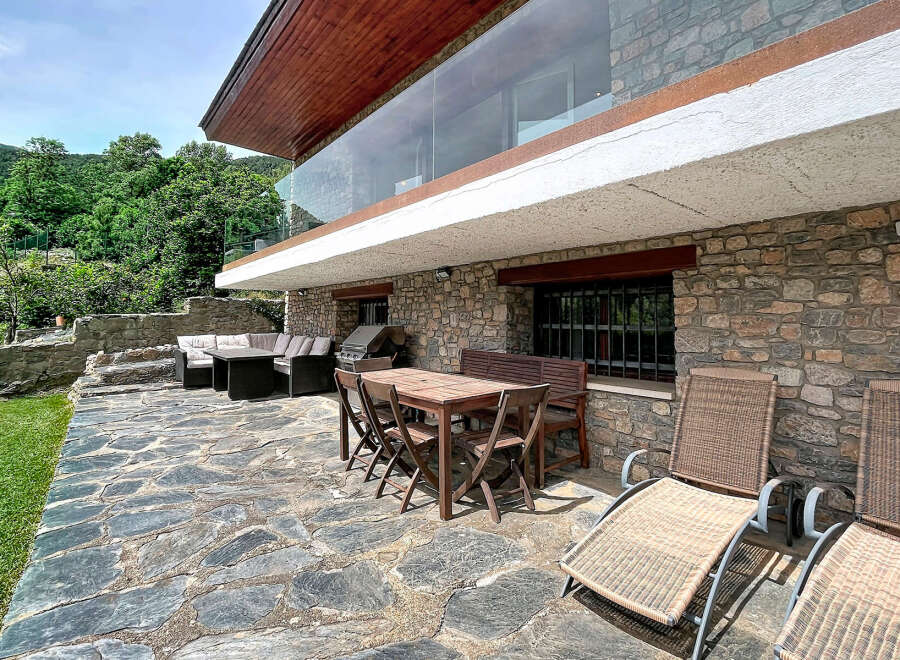Enjoy outdoor living with this spacious patio featuring a dining set, lounge chairs, and a grill, perfect for entertaining.