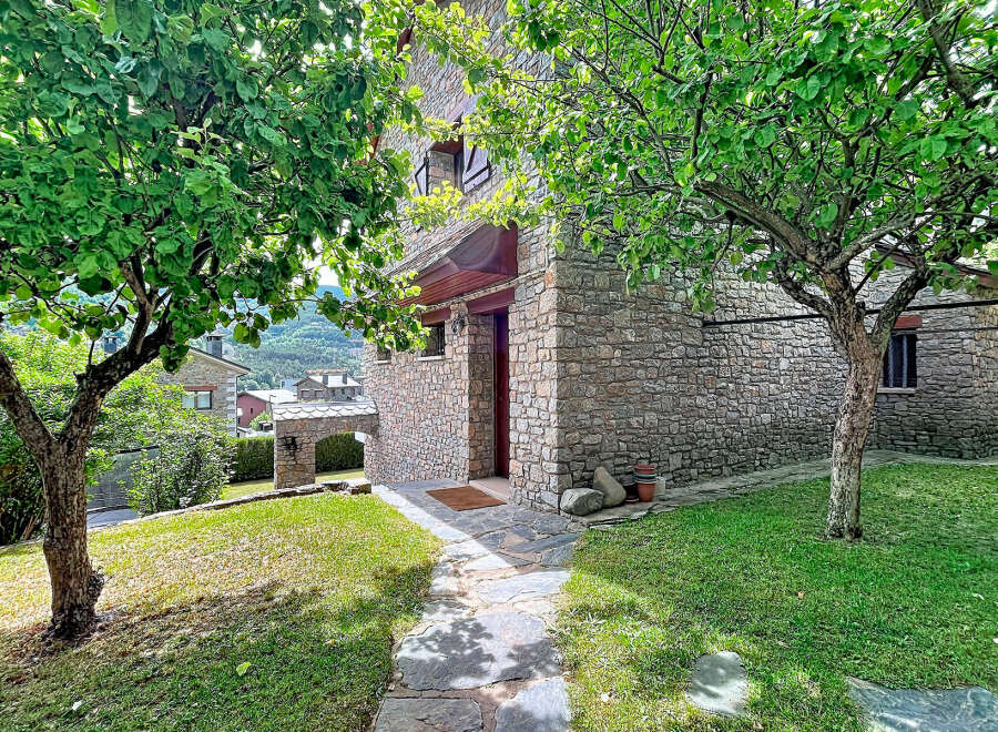 Discover this charming stone house nestled amidst lush greenery and mature trees, offering a serene retreat.