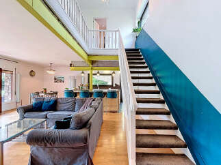 Experience modern living in this spacious open-concept home, featuring a stylish living area with a plush sectional sofa and a sleek glass coffee table.