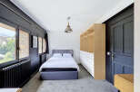 Discover this charming bedroom featuring a comfortable bed with a grey upholstered headboard, perfect for relaxation.