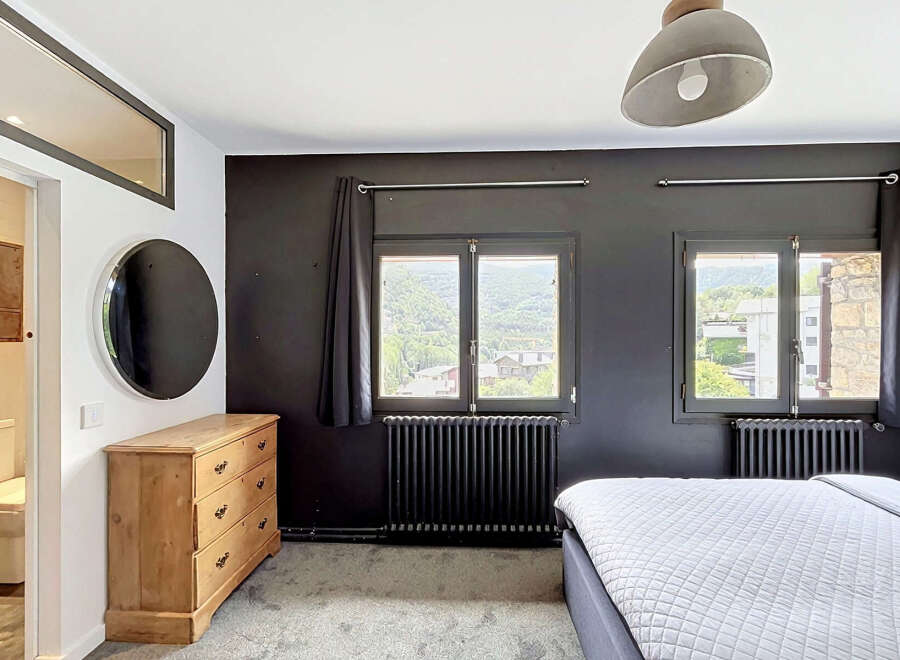 Experience comfort and style in this inviting bedroom, featuring a spacious bed and a charming wooden dresser.