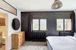 Experience comfort and style in this inviting bedroom, featuring a spacious bed and a charming wooden dresser.