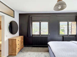Experience comfort and style in this inviting bedroom, featuring a spacious bed and a charming wooden dresser.