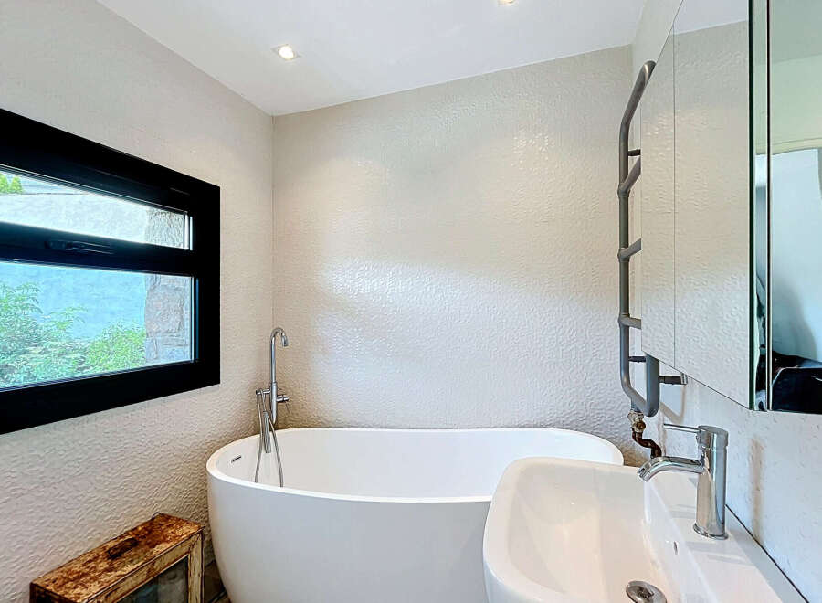 This modern bathroom features a freestanding bathtub and a sleek sink, perfect for a spa-like experience at home.