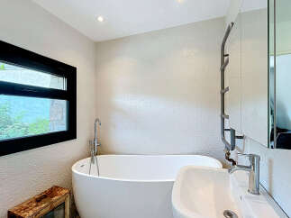 This modern bathroom features a freestanding bathtub and a sleek sink, perfect for a spa-like experience at home.