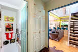 Step into this charming home featuring a unique teal door and a striking built-in cabinet with antique hardware.