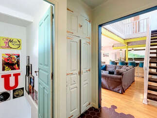 Step into this charming home featuring a unique teal door and a striking built-in cabinet with antique hardware.