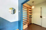Discover this charming entryway featuring a unique circular mirror and a striking blue and white accent wall.