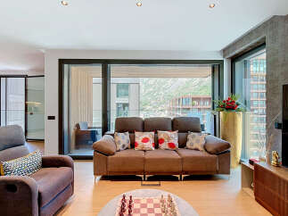 Experience modern living in this spacious living room, featuring a comfortable brown sofa adorned with decorative pillows and a large sliding glass door offering stunning mountain views.