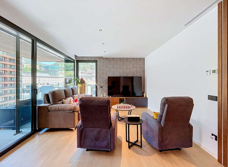 Experience modern living in this spacious living room featuring a comfortable sofa and two plush armchairs, perfect for relaxation.
