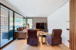 Experience modern living in this spacious living room featuring a comfortable sofa and two plush armchairs, perfect for relaxation.