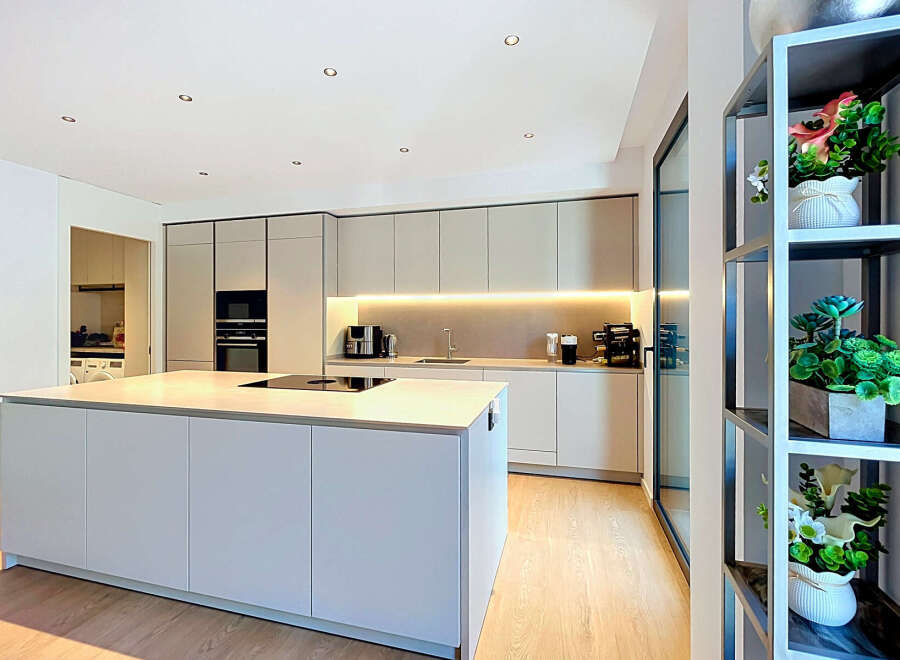 Experience modern living in this stunning kitchen featuring a sleek island with a built-in stovetop, perfect for culinary creations.