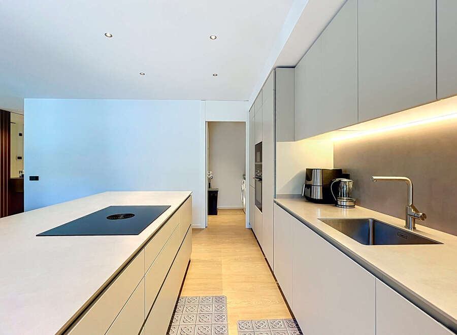 Experience modern living in this sleek kitchen featuring a spacious island with an integrated induction cooktop.