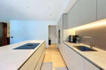 Experience modern living in this sleek kitchen featuring a spacious island with an integrated induction cooktop.