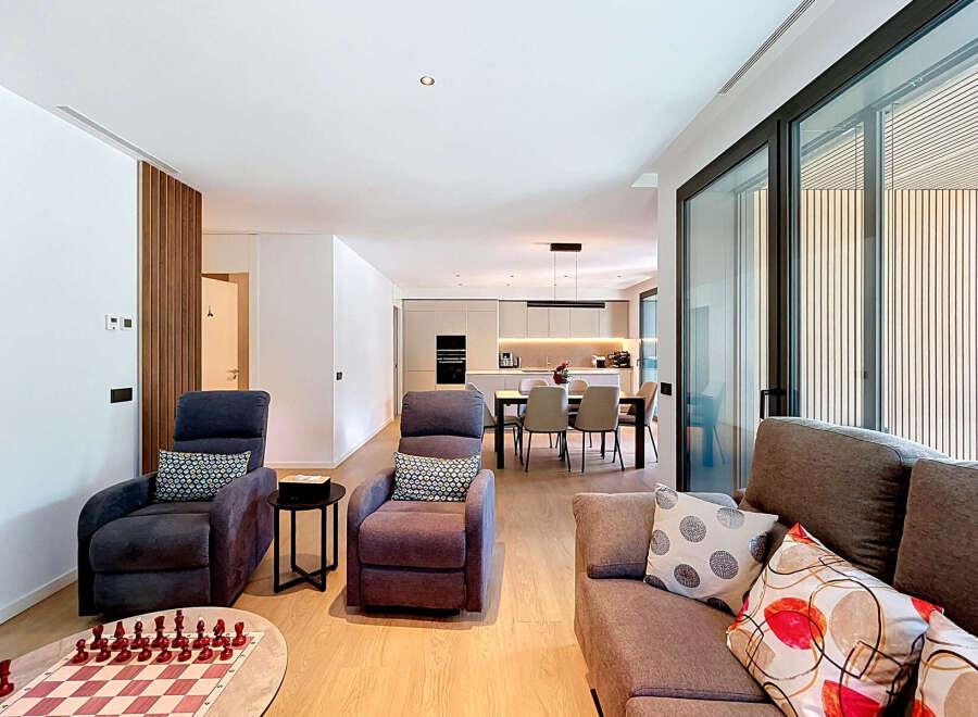 Experience modern living in this spacious open-plan apartment, featuring a sleek, integrated kitchen and a comfortable living area perfect for relaxation and entertainment.