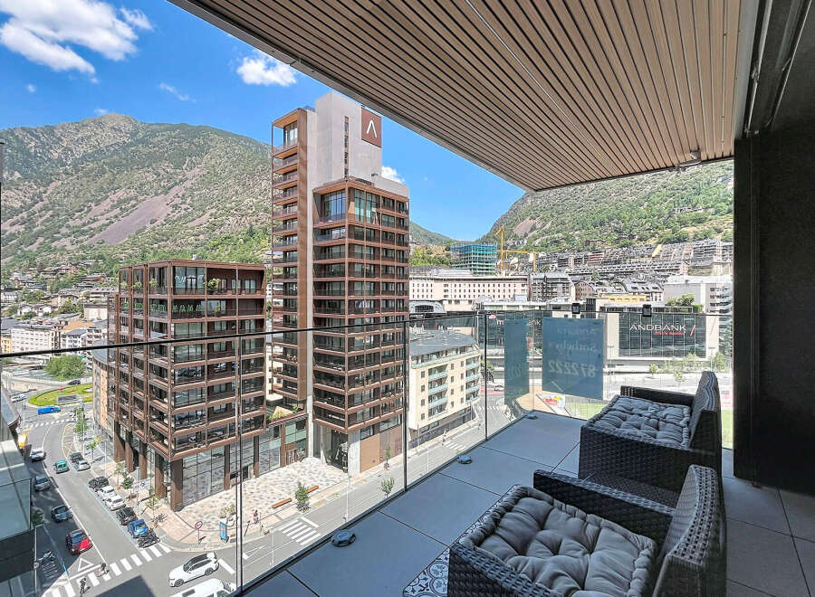 Experience modern living with this stunning balcony view, showcasing contemporary architecture nestled against a majestic mountain backdrop.