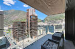 Experience modern living with this stunning balcony view, showcasing contemporary architecture nestled against a majestic mountain backdrop.