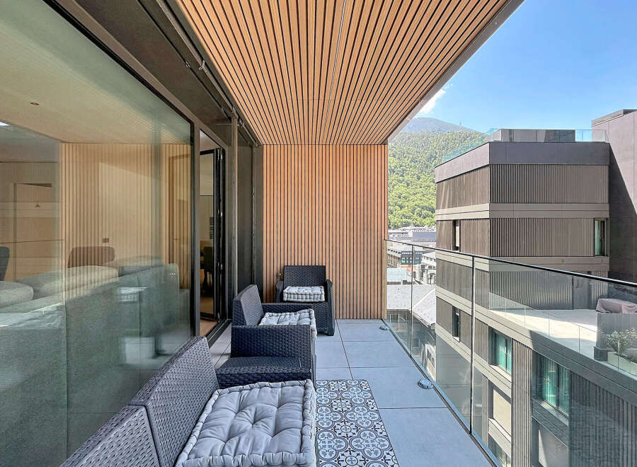 Experience luxurious outdoor living on this spacious balcony, featuring comfortable seating and a stylish tiled accent.