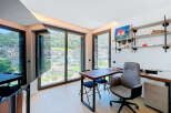 Experience breathtaking mountain and city views from this modern home office, featuring expansive windows that flood the space with natural light.