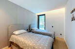 This modern bedroom features two comfortable twin beds with stylish grey headboards and star-patterned comforters.