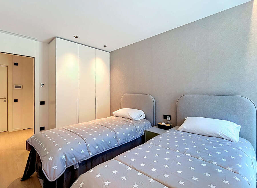 This modern bedroom features two twin beds with charming star-patterned comforters, perfect for a guest room or children's space.