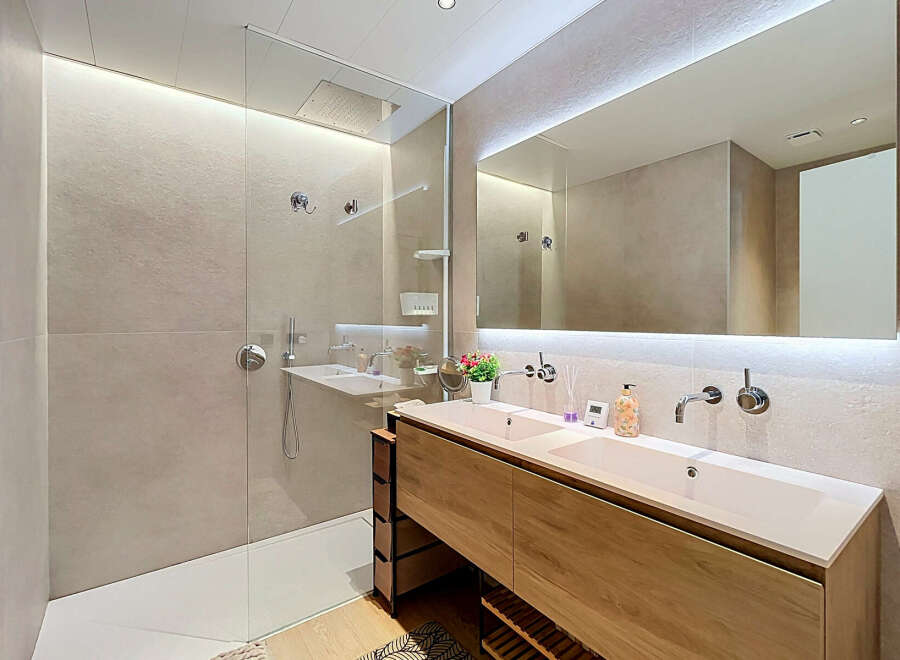 Experience modern luxury in this stunning bathroom featuring a spacious walk-in shower with a rainfall showerhead and a sleek double vanity with ample counter space.