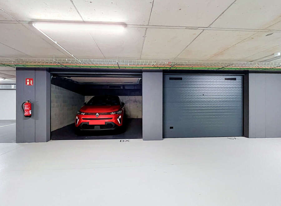 Discover this modern underground parking space featuring a sleek red electric vehicle.