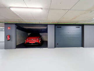 Discover this modern underground parking space featuring a sleek red electric vehicle.