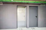 Discover modern functionality with two distinct doors, one open to reveal a clean, unfinished interior, and the other a closed grey metal door with ventilation slots.
