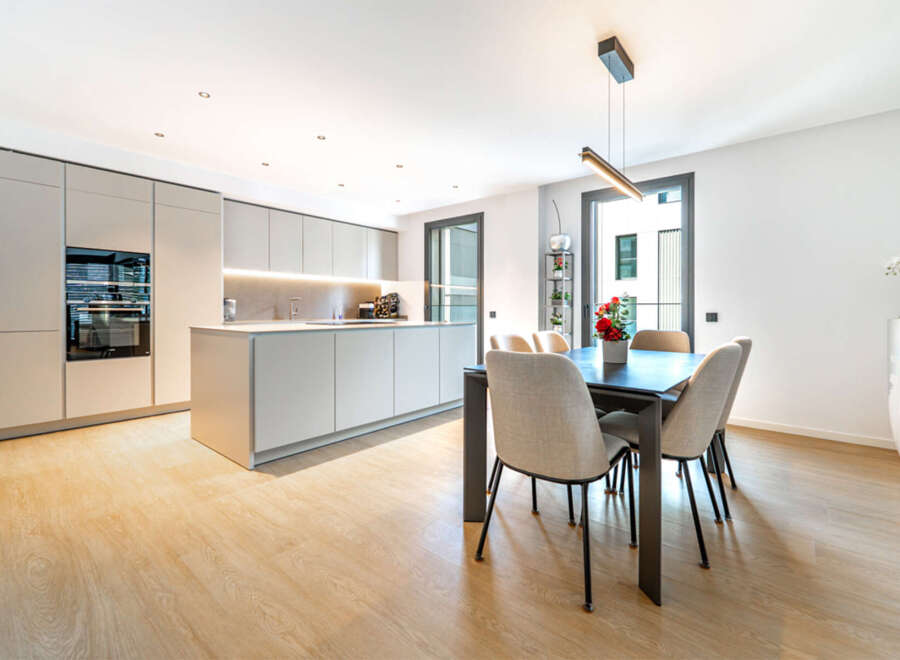 Experience modern living in this stunning kitchen and dining area, featuring sleek, integrated cabinetry and a spacious island perfect for meal preparation and casual dining.