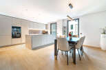 Experience modern living in this stunning kitchen and dining area, featuring sleek, integrated cabinetry and a spacious island perfect for meal preparation and casual dining.