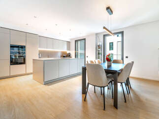 Experience modern living in this stunning kitchen and dining area, featuring sleek, integrated cabinetry and a spacious island perfect for meal preparation and casual dining.