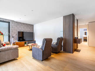This modern living room features a comfortable grey sofa and two recliners, perfect for relaxation.